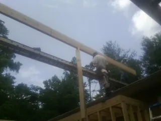 Carpenter setting a ridge beam over a new addition frame — Ice Dam Removal by Roofing Brothers in Sweet Springs
