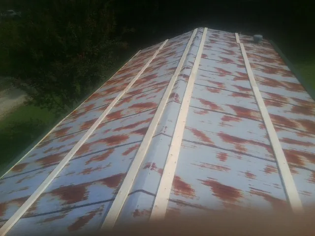 Rusted metal roof panels with new wood purlins before replacement — Storm Damage Roof Repair in Sweet Springs by Roofing Brothers