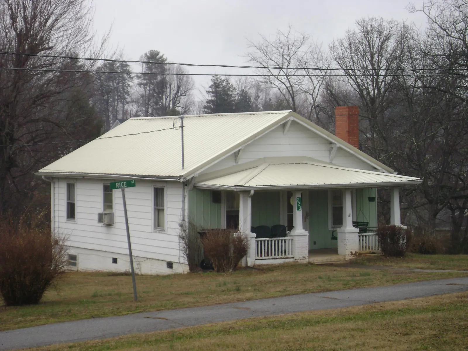 White metal roof on a craftsman bungalow at a street corner in Sweet Springs