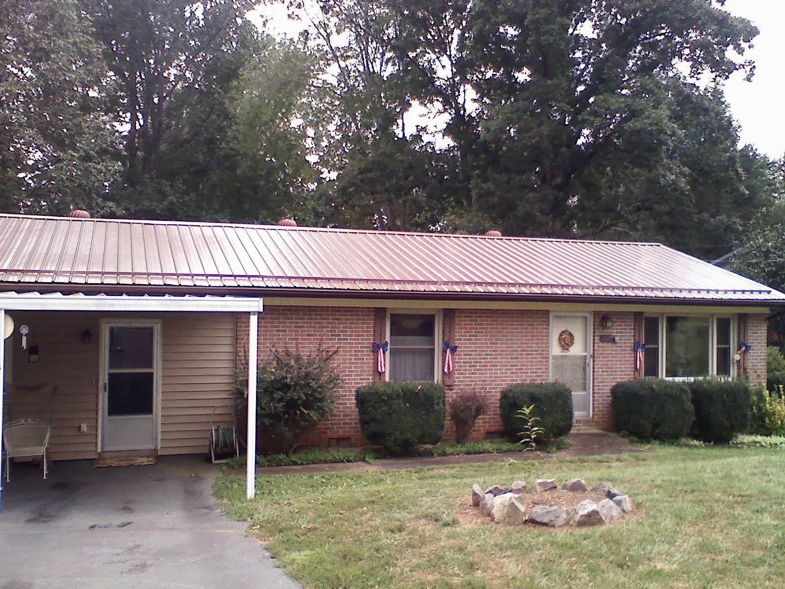 Bronze metal roof and carport on a brick ranch home — Roof Repair work by our crew in Sweet Springs