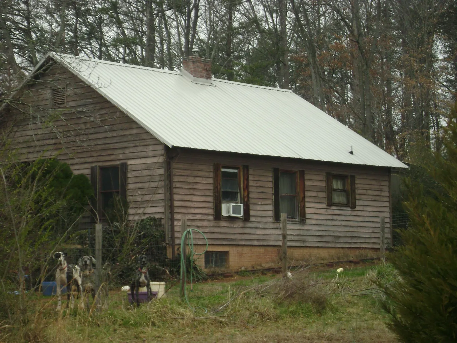 White metal roof on an old wood sided farmhouse, from a Metal Roof Installation job in Sweet Springs